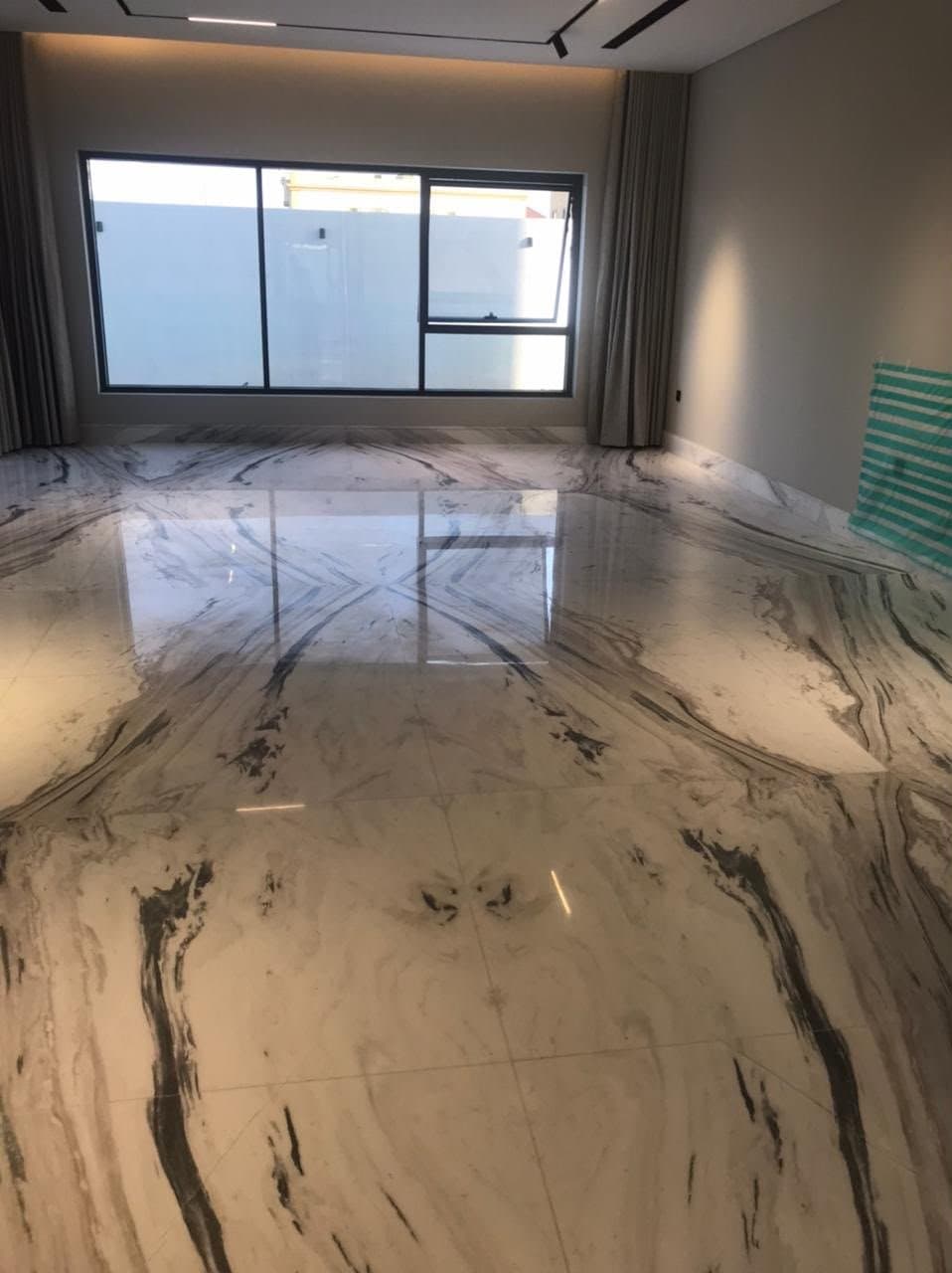 Bookmatched marble flooring with dramatic dark veining in a living room