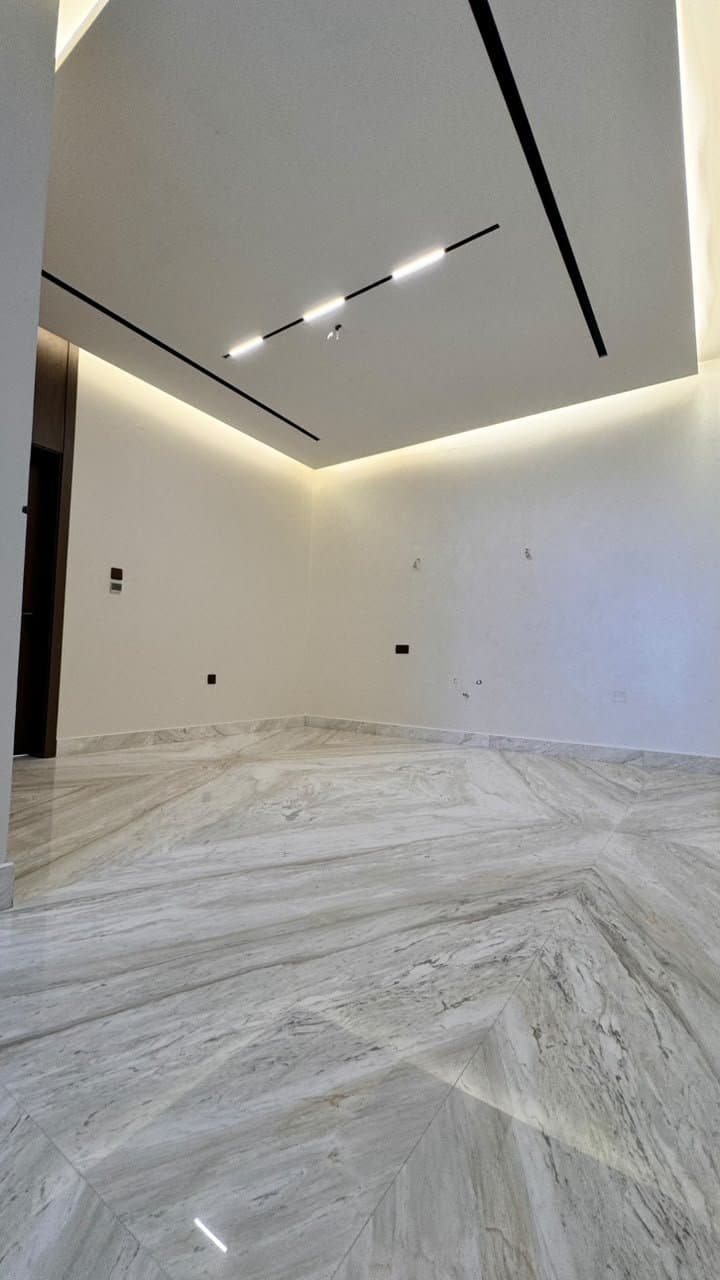 Bookmatched marble flooring with diamond veining pattern in a bedroom
