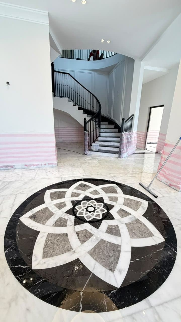 Marble floor medallion at the base of a curved staircase