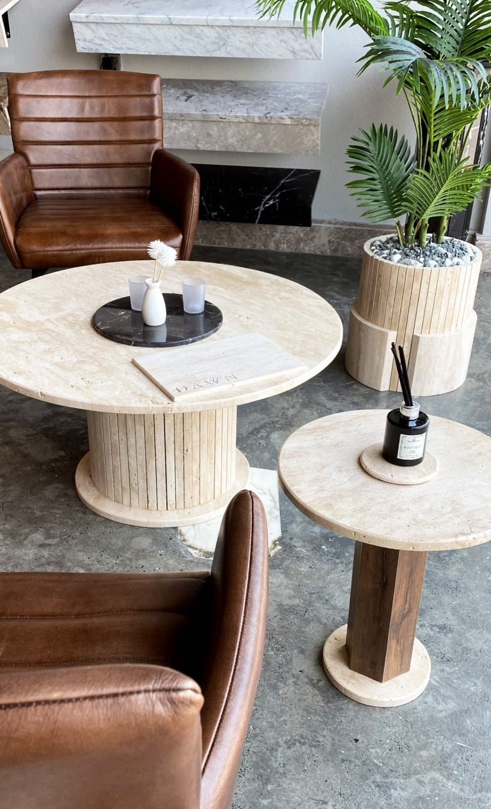 Round travertine coffee and side tables with ribbed pedestal bases