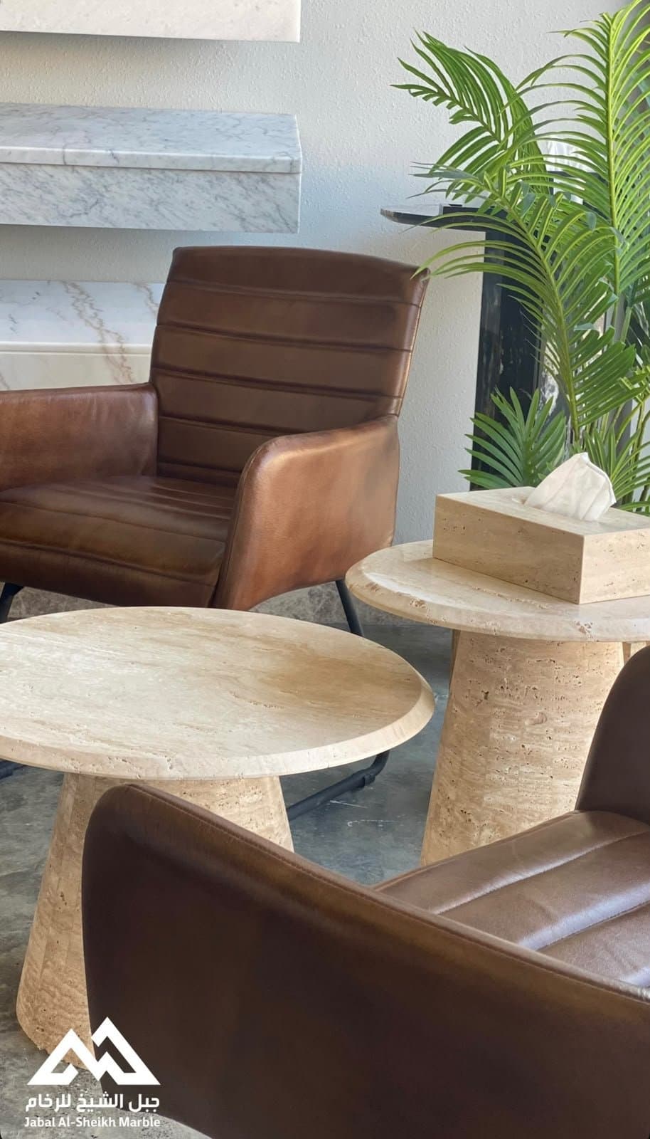 Round travertine coffee tables in a seating area
