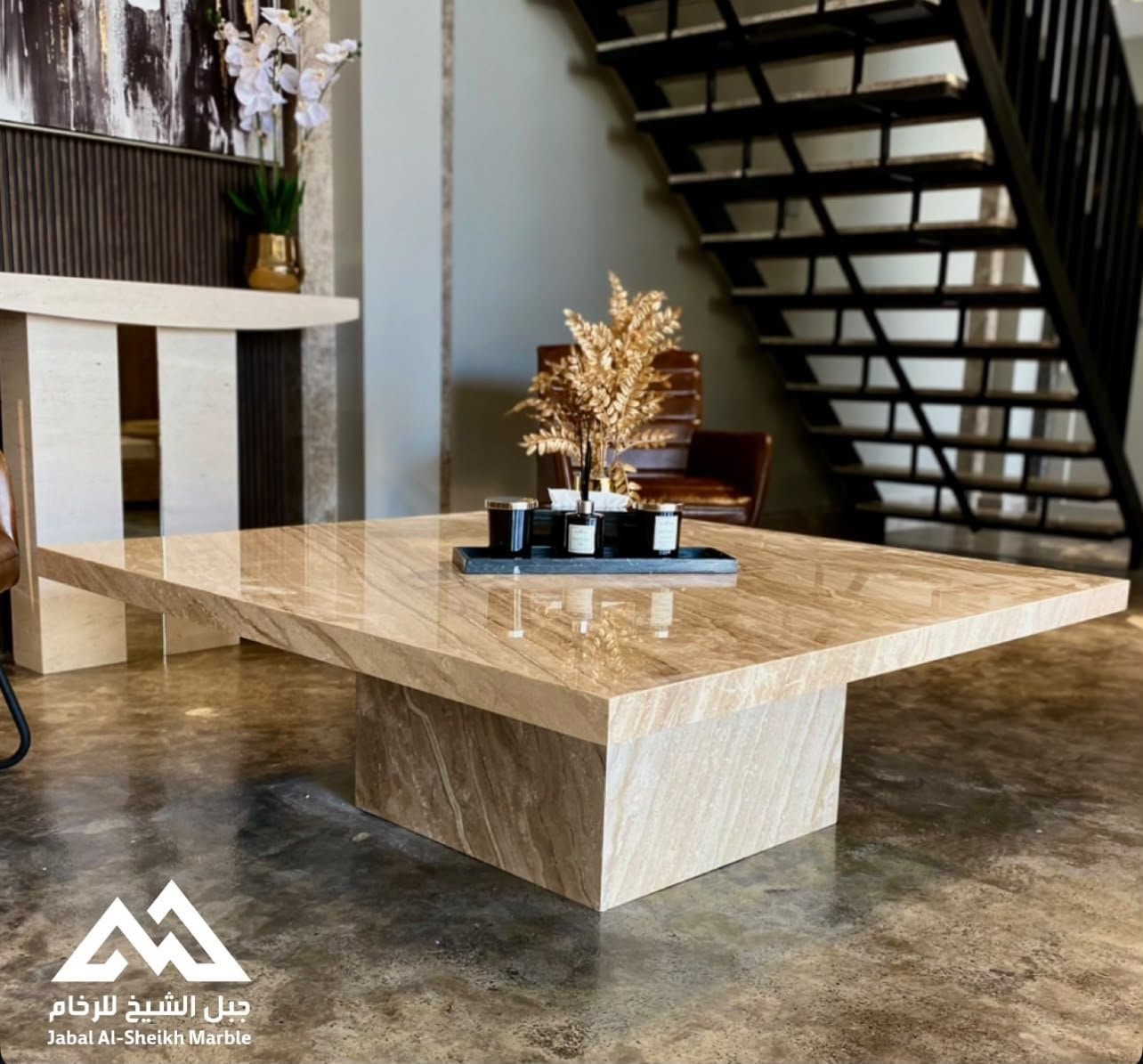 Square polished travertine coffee table beside a staircase