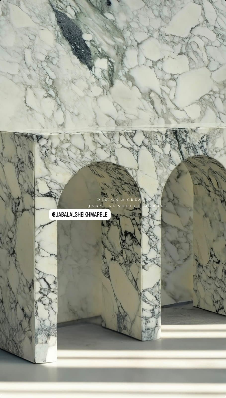 Arched marble bench carved from a single dramatic slab