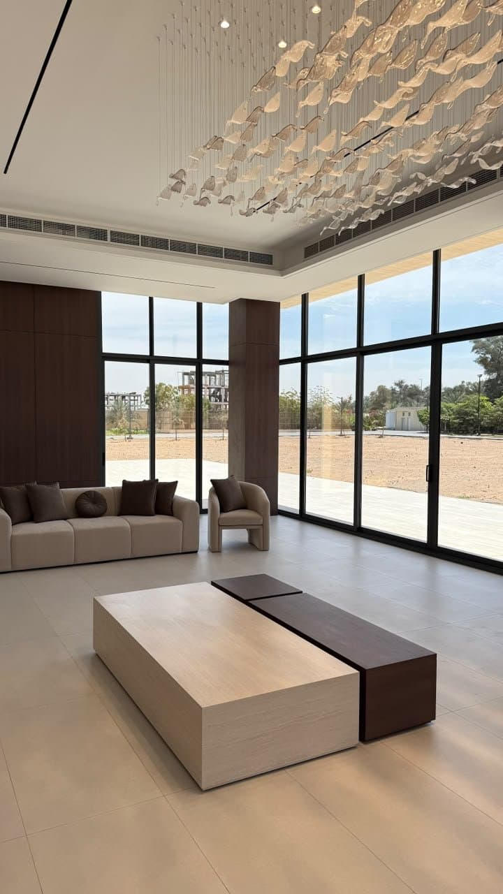 Two-tone waterfall coffee table in a living room with sculptural pendant lighting
