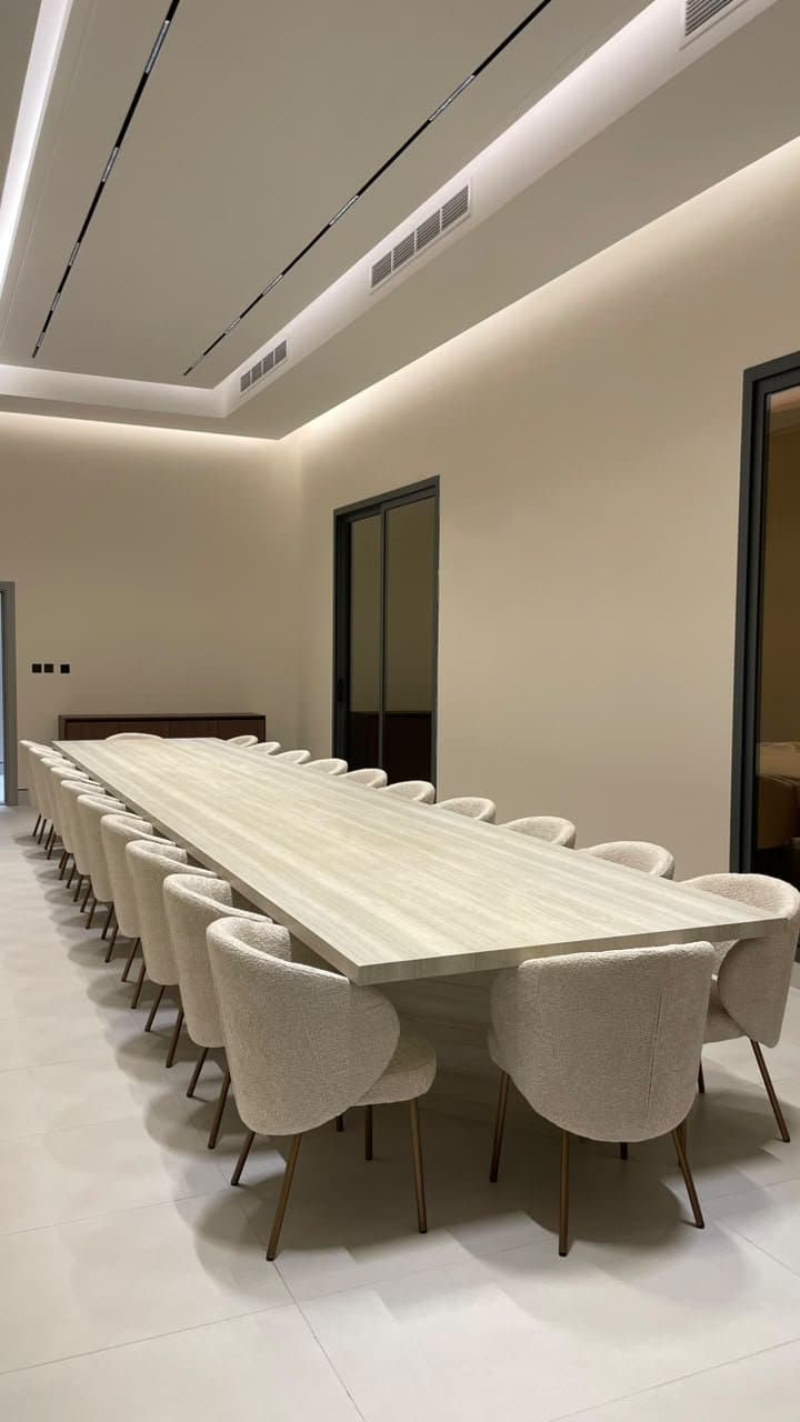 Long travertine boardroom table with upholstered chairs