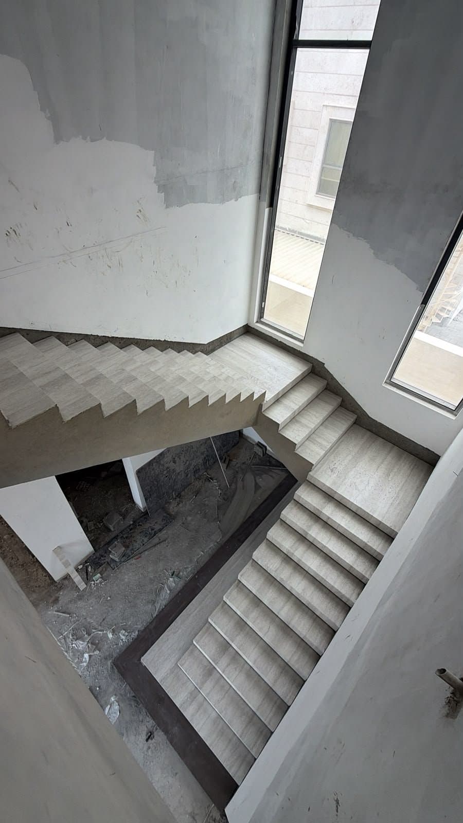 Aerial view of a switchback travertine staircase mid-construction