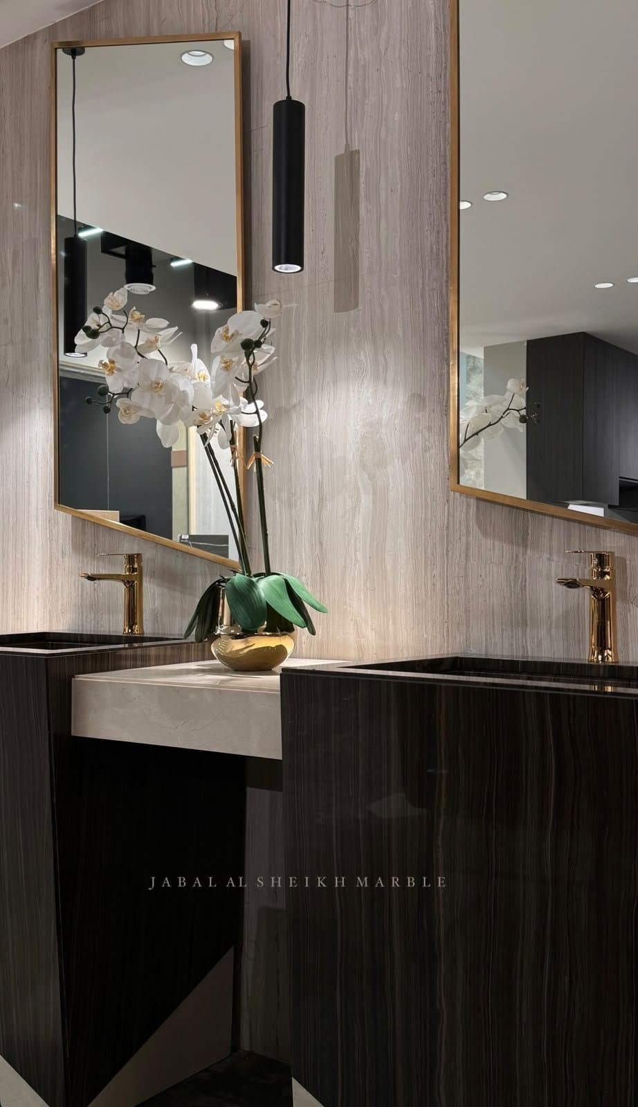 Double vanity with gold-framed mirrors, gold fixtures, and dark wood cabinetry