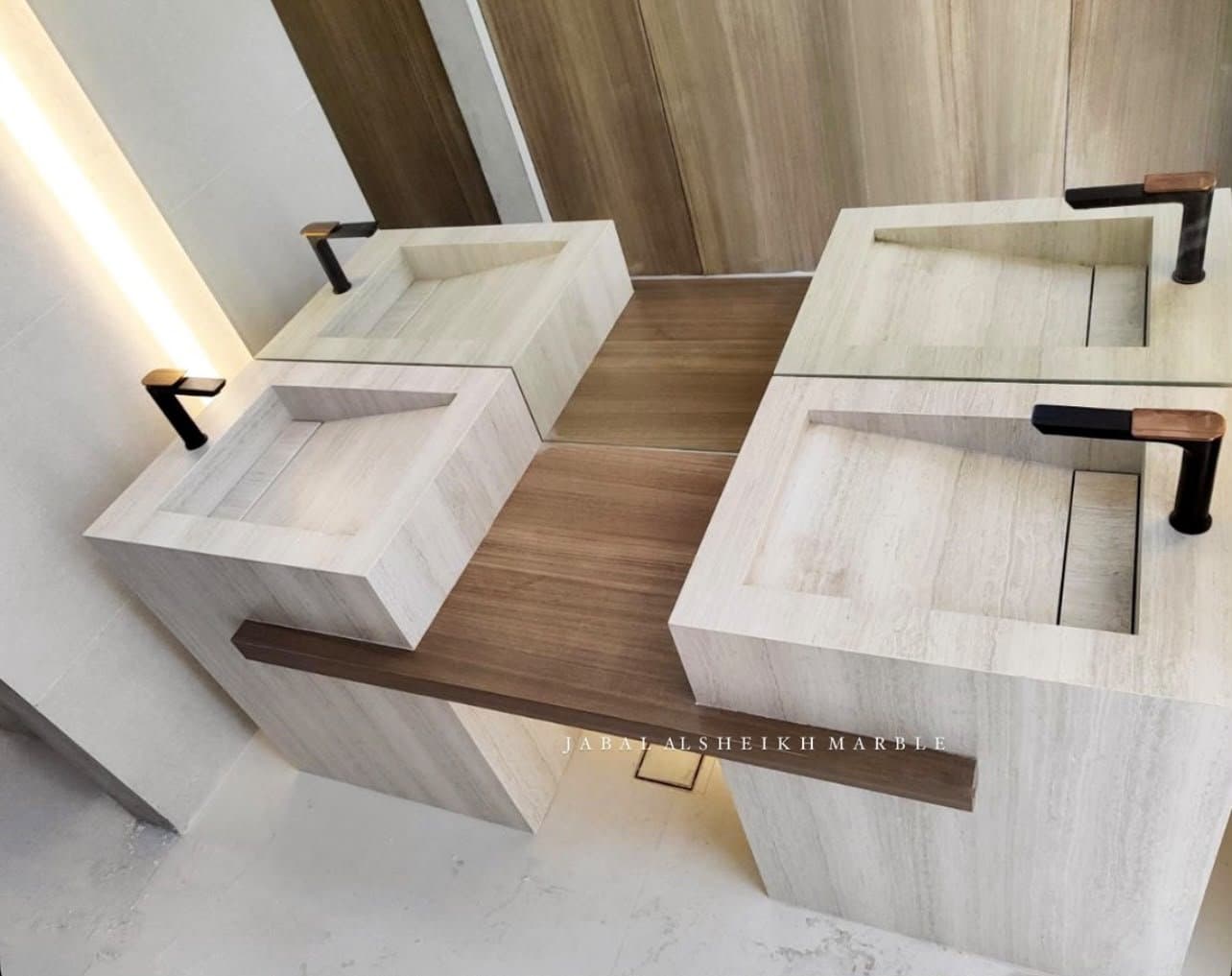 Travertine double vanity with angled trough sinks and mixed black and copper faucets
