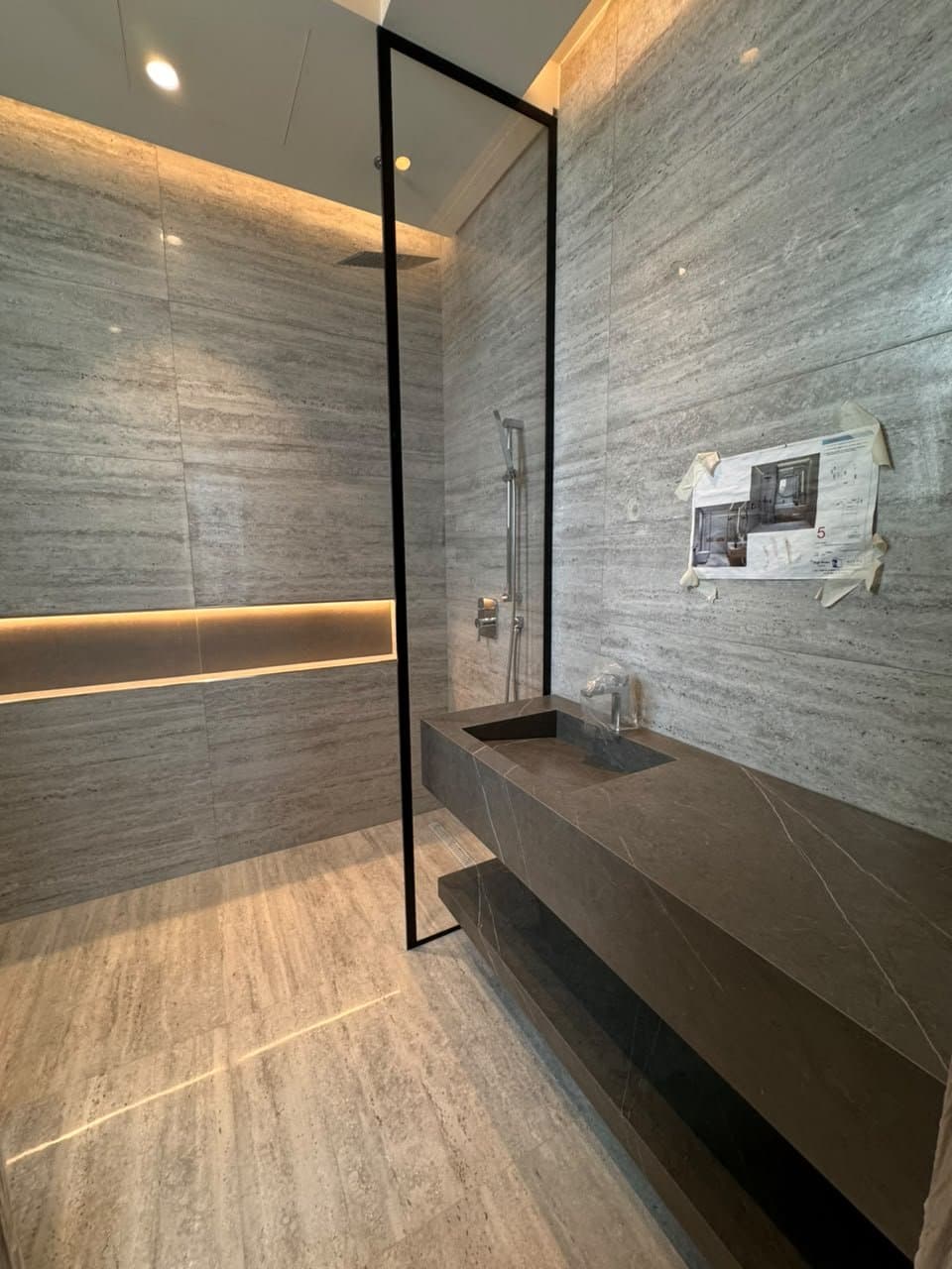 Grey stone single vanity in a walk-in shower area