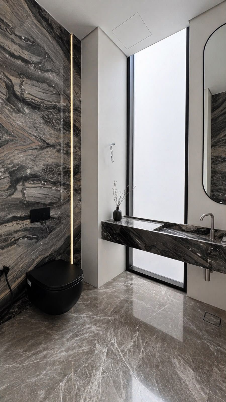 Dark swirled stone bathroom with black toilet and matching wall cladding
