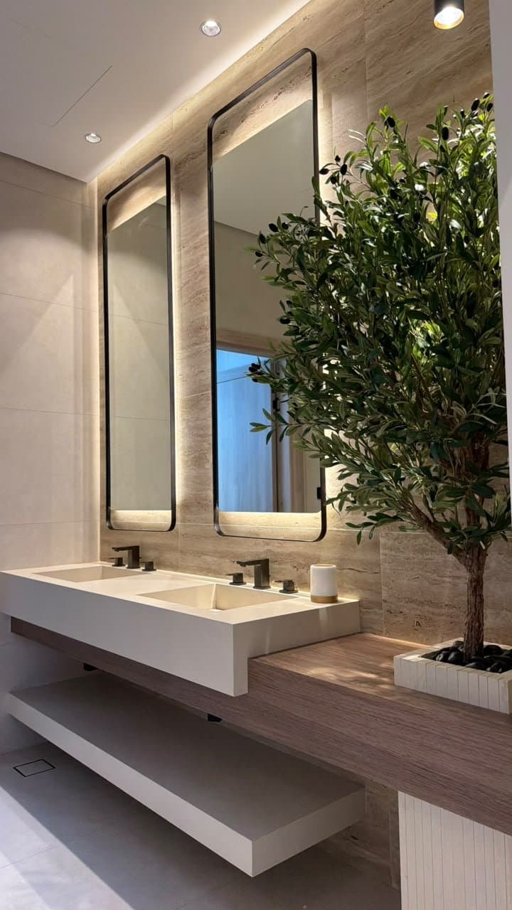 Travertine double sink vanity with tall mirrors beside an olive tree
