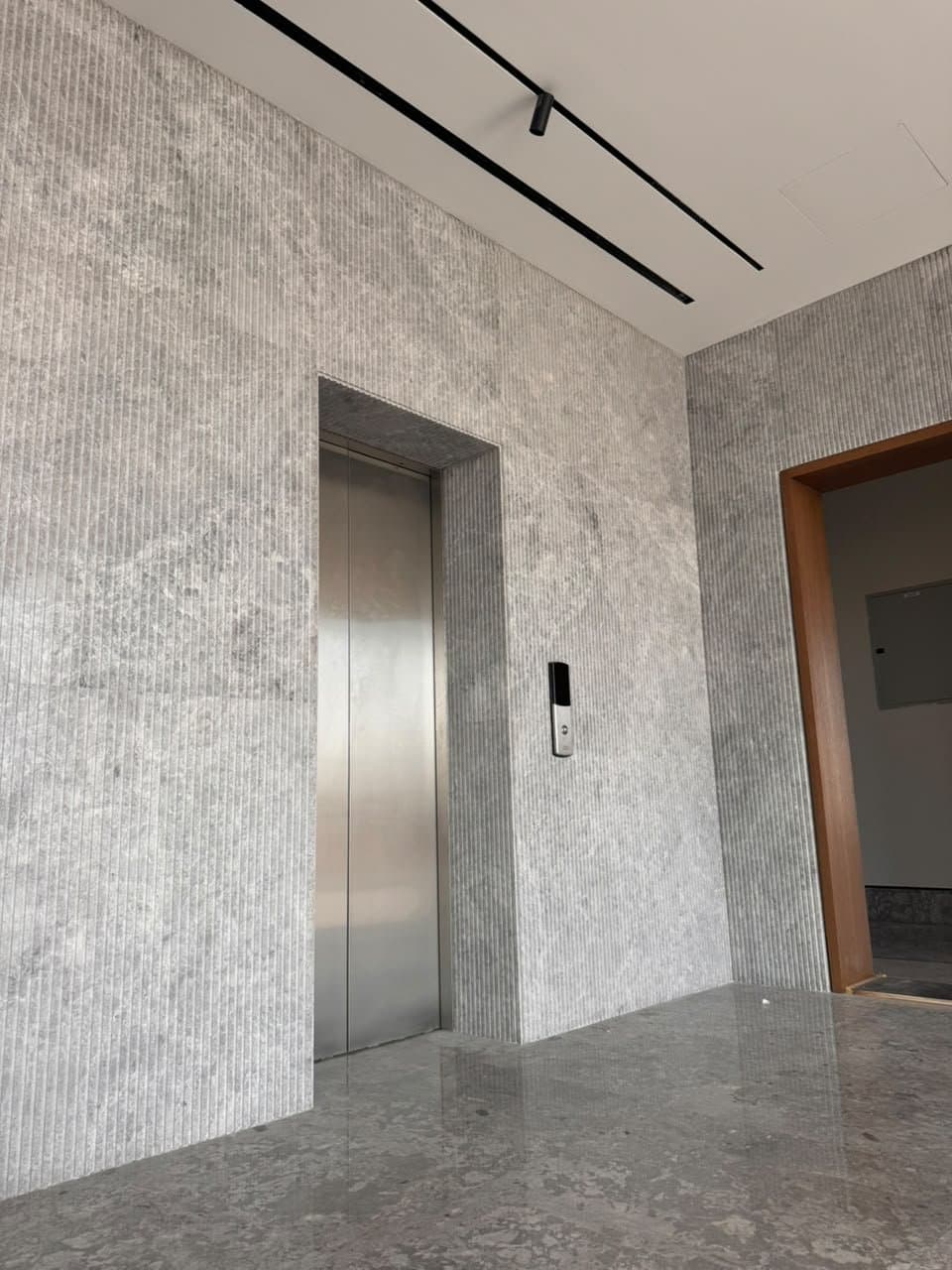 Fluted grey stone cladding surrounding an elevator entrance