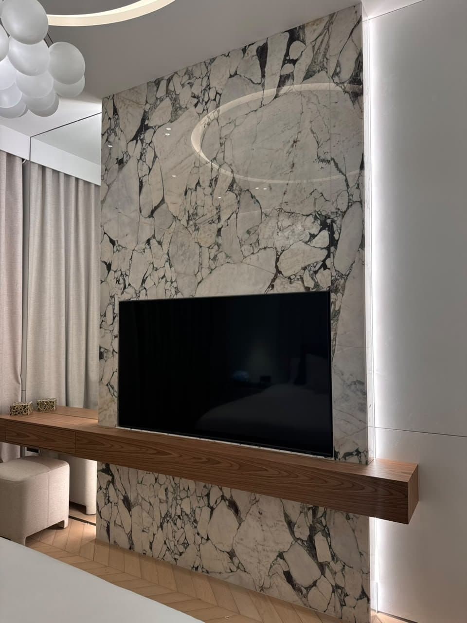 Bookmatched marble feature wall behind a mounted television