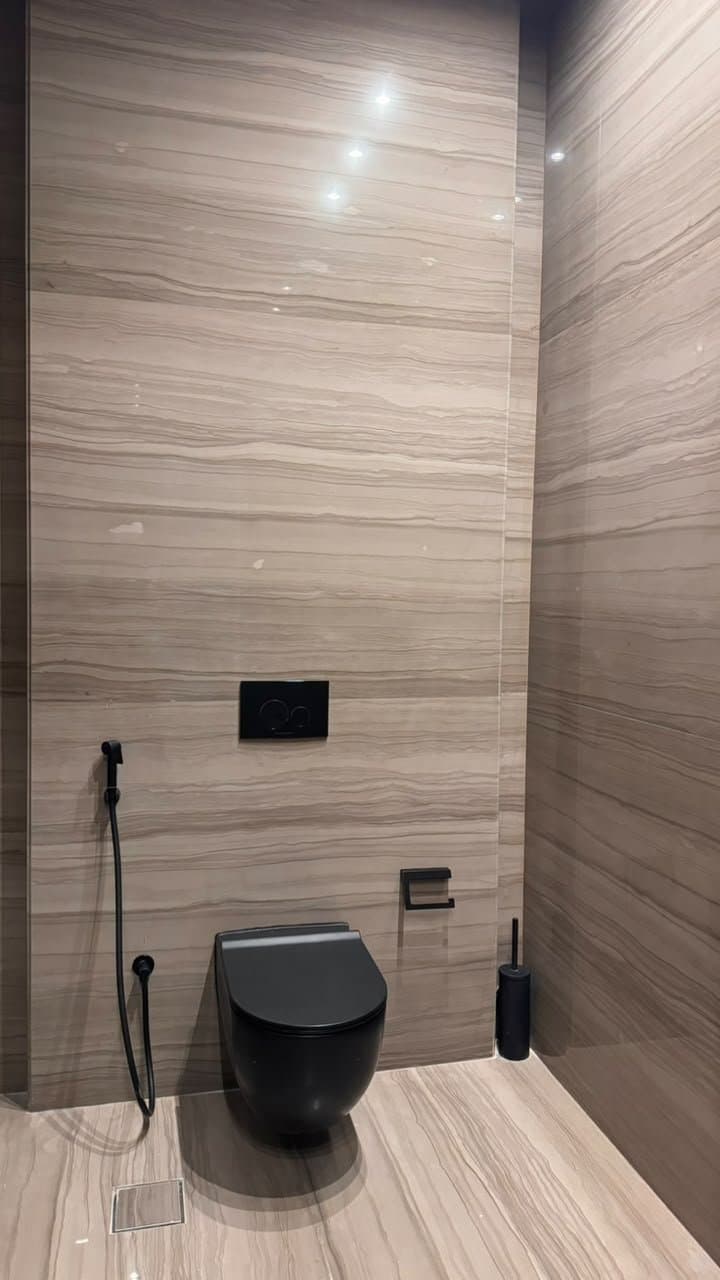 Striped marble wall cladding in a powder room with matte black fixtures
