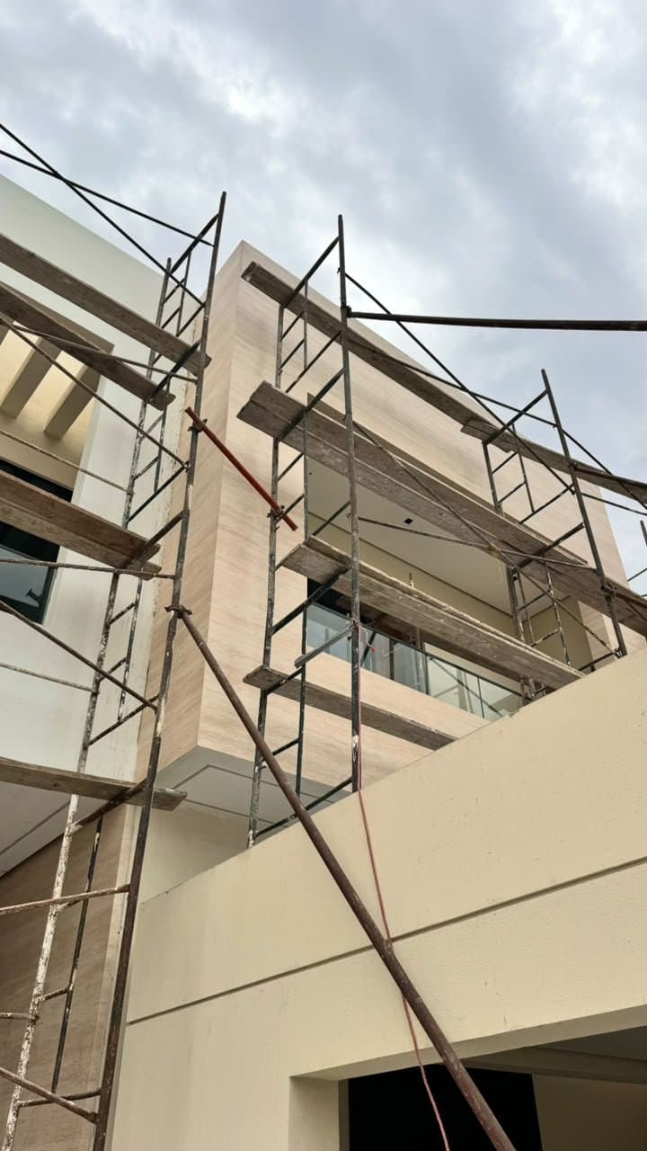 Travertine-clad villa exterior during construction