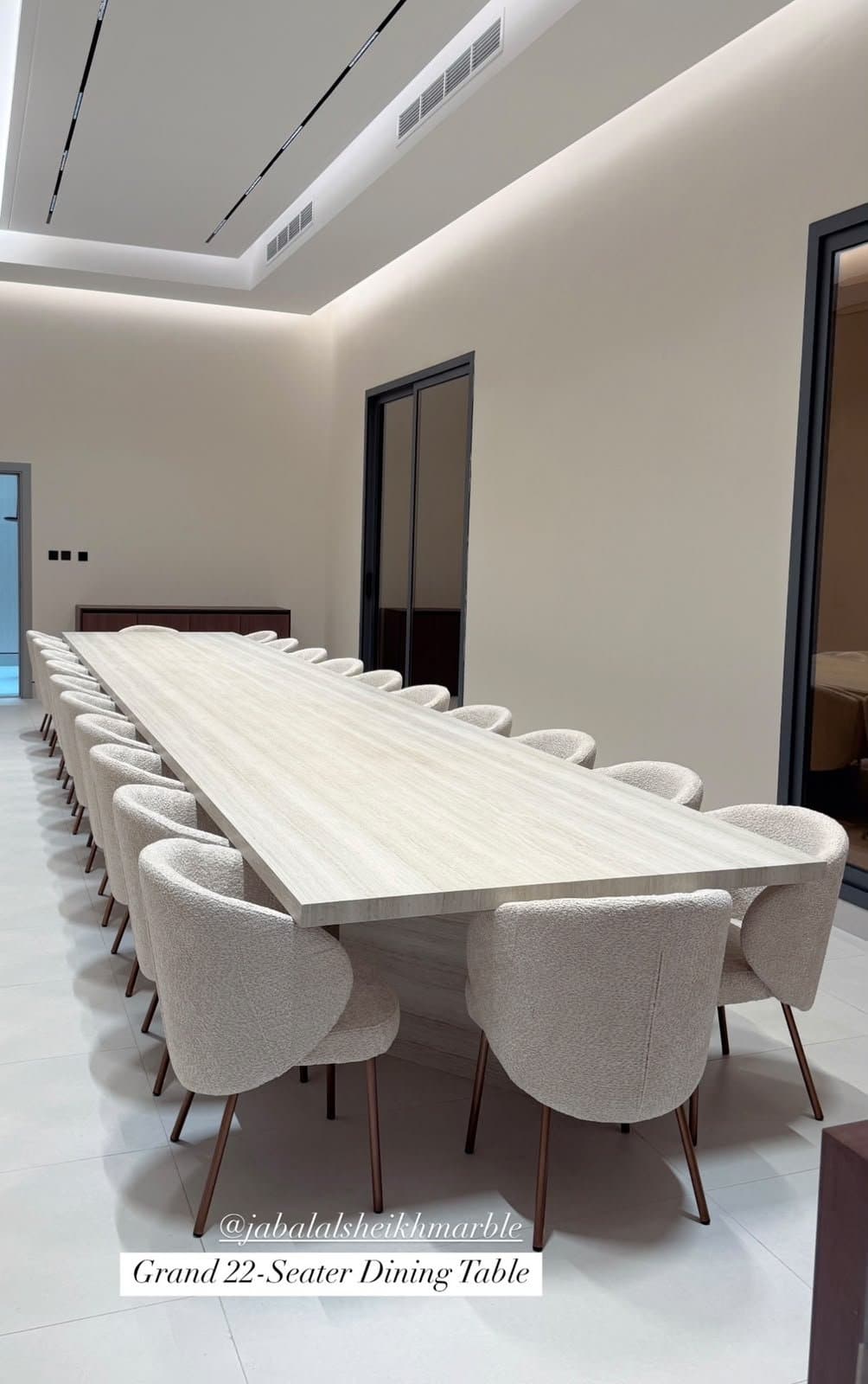 Grand 22-seater dining table in travertine, seen from the head of the table