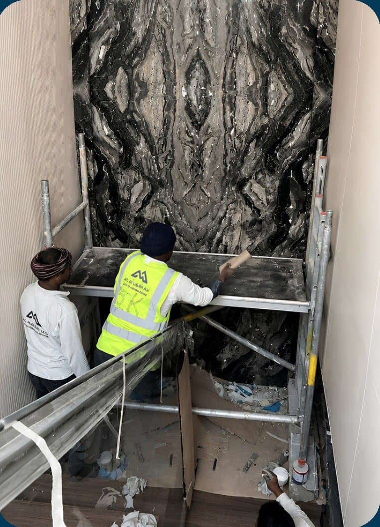 Book-matched dark stone cladding installation